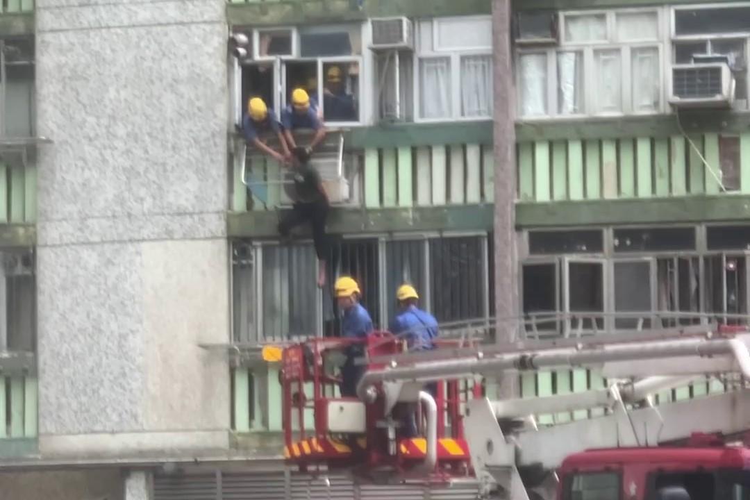 順天邨有女子危坐外牆晾衫架,街坊直擊消防員合力救人過程。(網上影片截圖)