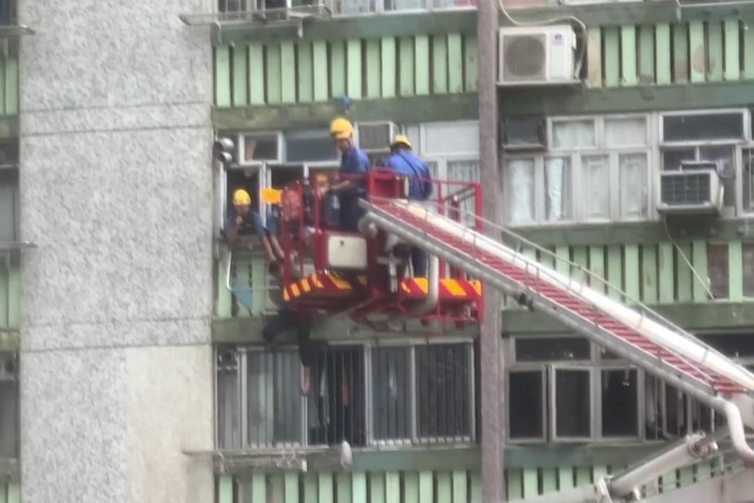 順天邨有女子危坐外牆晾衫架,街坊直擊消防員合力救人過程。(網上影片截圖)