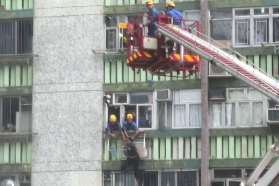 順天邨有女子危坐外牆晾衫架,街坊直擊消防員合力救人過程。(網上影片截圖)