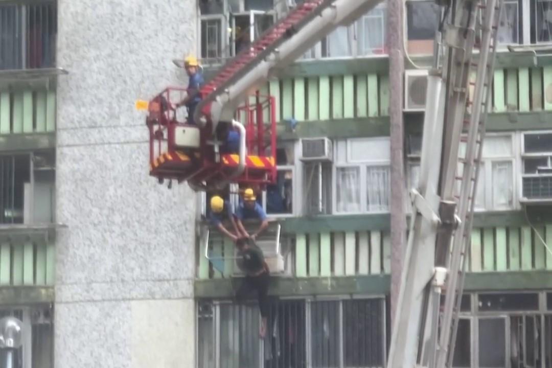 順天邨有女子危坐外牆晾衫架,街坊直擊消防員合力救人過程。(網上影片截圖)