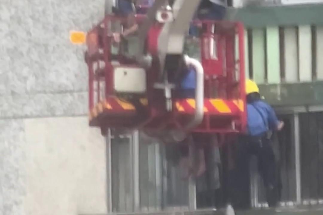 順天邨有女子危坐外牆晾衫架,街坊直擊消防員合力救人過程。(網上影片截圖)
