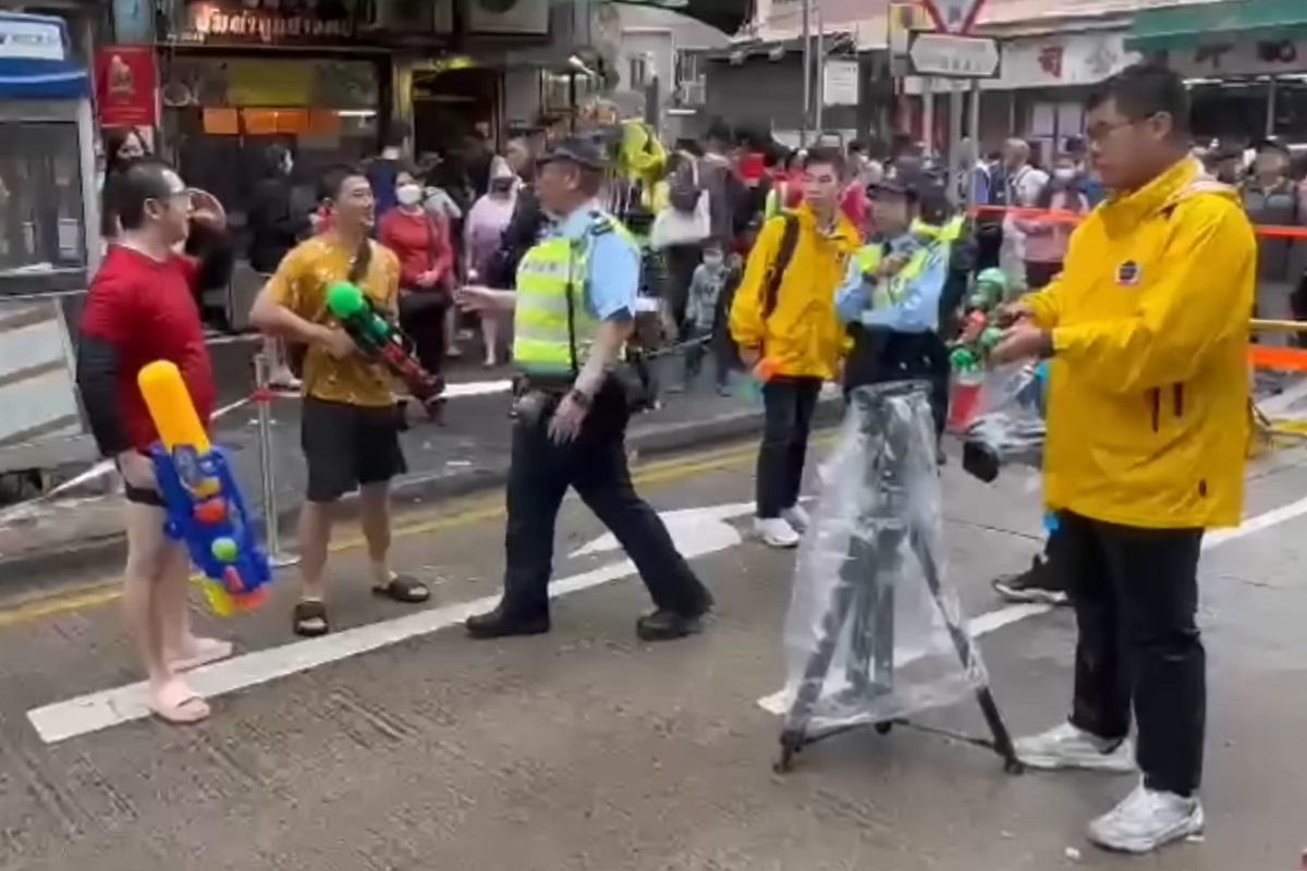 九龍城潑水節日前舉行,有警員勸止向無綫新聞記者射水的行為。(YouTube頻道「Bravedogdog」影片截圖)
