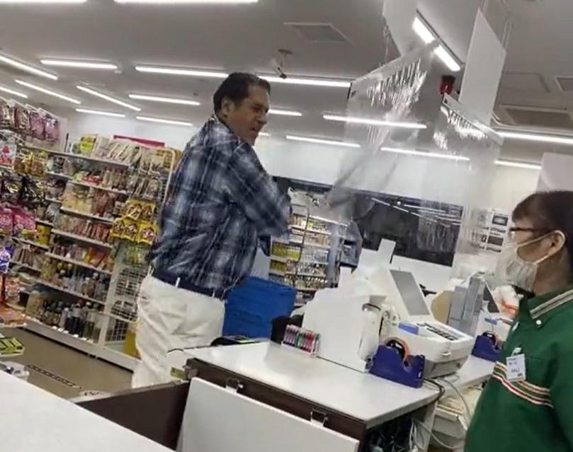 男子拍打店內的膠幕。(影片截圖)