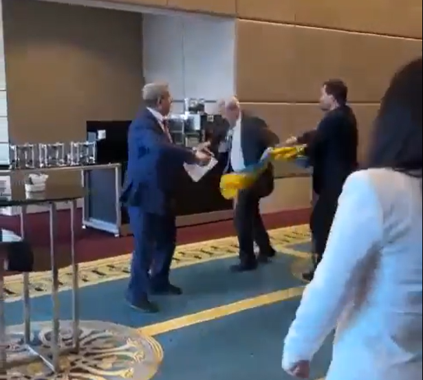 俄羅斯代表繼續捉住烏克蘭國旗,烏代表於是繼續揮拳。(影片截圖)