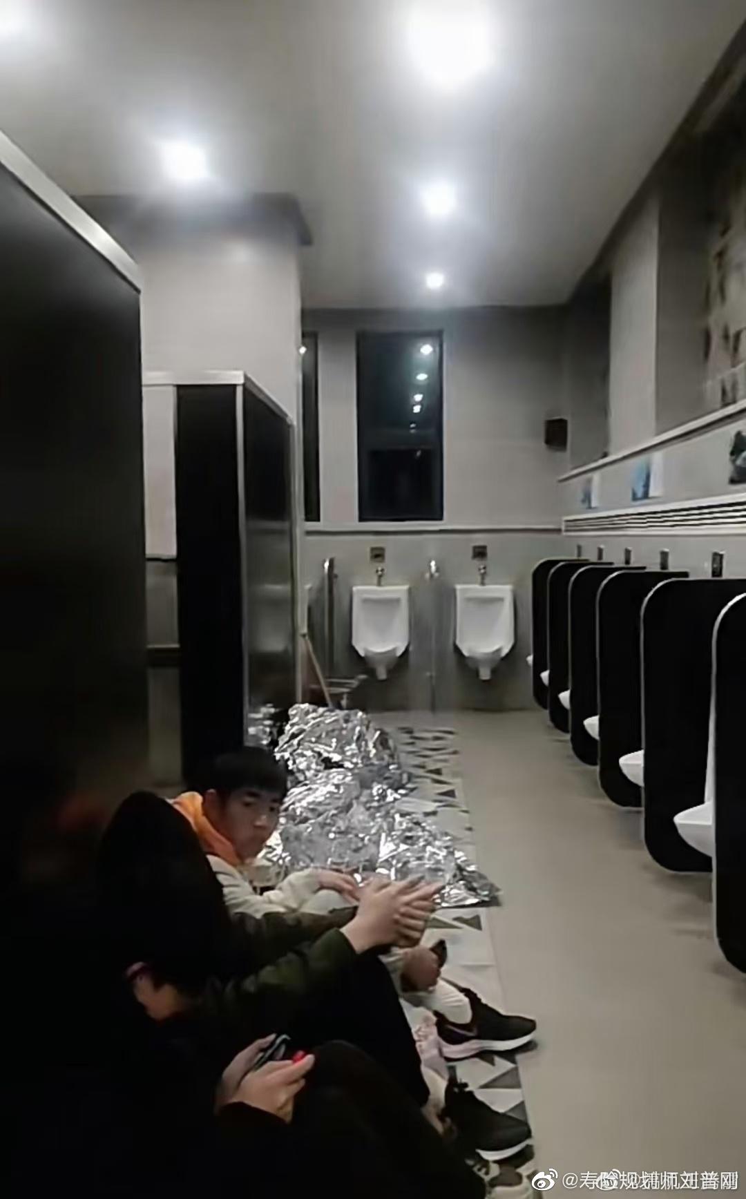 公廁的走廊擠滿密密麻麻的遊客,有的躺著、坐著、站著,甚至還有人蓋上毯子直接倒頭大睡。(微博)