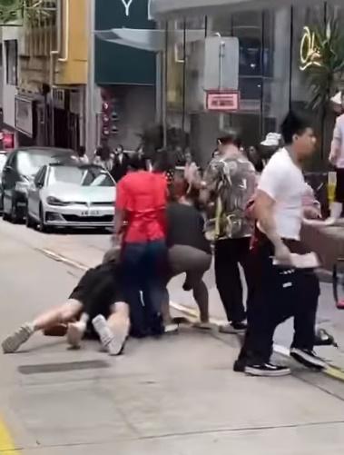 3名男子在士丹利街馬路中心扭作一團,有人倒地,多人圍觀。(FB)