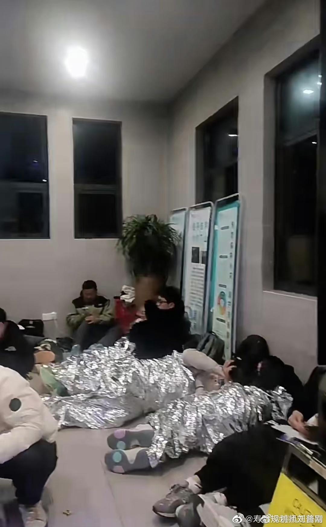 公廁的走廊擠滿密密麻麻的遊客,有的躺著、坐著、站著,甚至還有人蓋上毯子直接倒頭大睡。(微博)