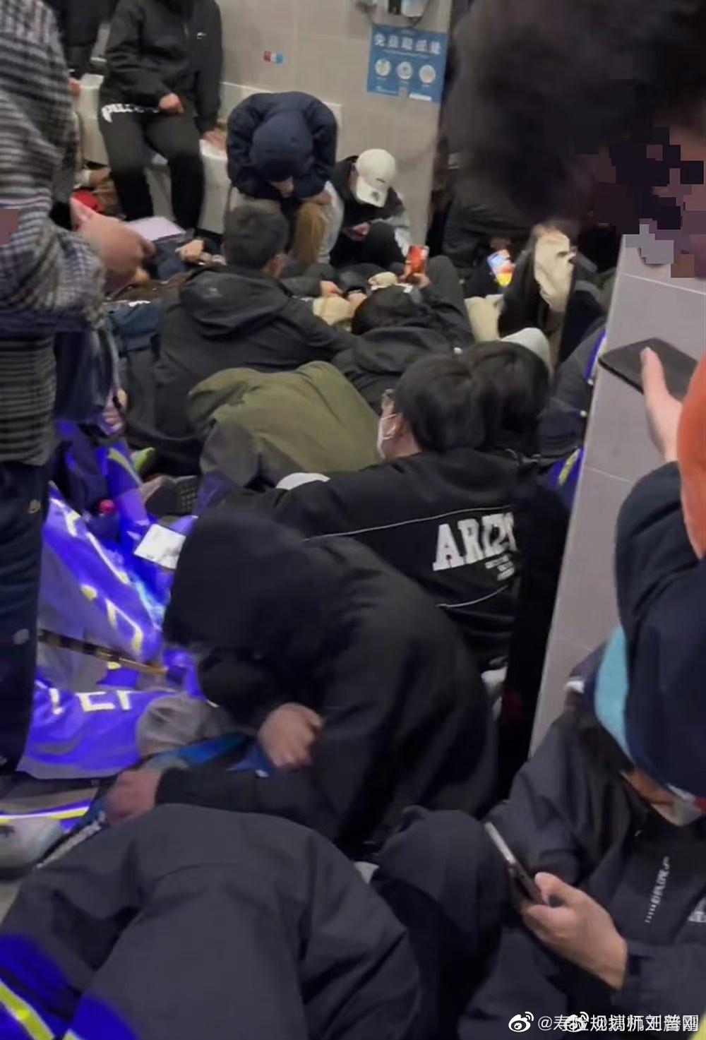 公廁的走廊擠滿密密麻麻的遊客,有的躺著、坐著、站著,甚至還有人蓋上毯子直接倒頭大睡。(微博)