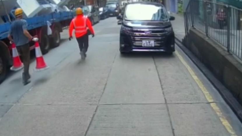 工字鐵滑下約20米後停下,兩名工人持著兩個雪糕筒前往處理。(HongKong CarCam@FB)