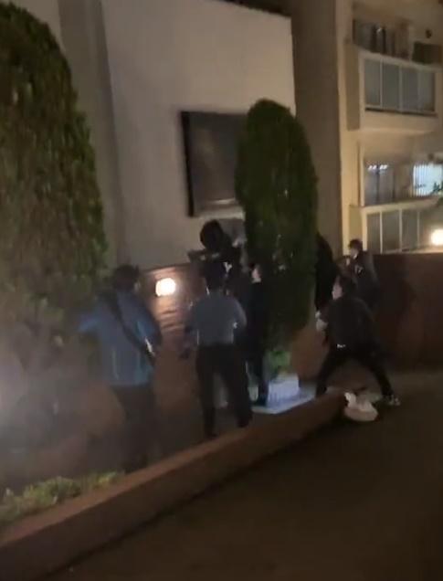 警員將一名男子由圍牆上拉到地面,多名警員一哄而上將他拘捕。(Twitter)