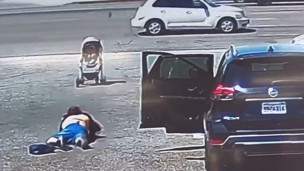 婦人心急要抓住,卻不慎跌倒,眼見嬰兒車要衝入車群。(Twitter)