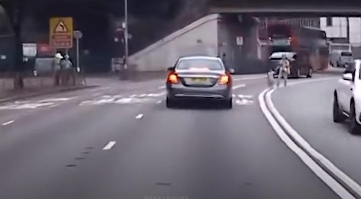 中年婦棄用行人天橋,抱B拖女亂過馬路。(網片截圖)