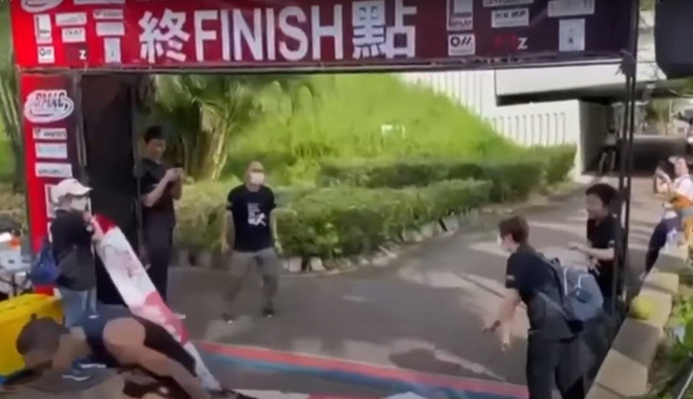 女義工鬆手放下了衝線帶,葉雅傑差點被絆倒。(網片截圖)