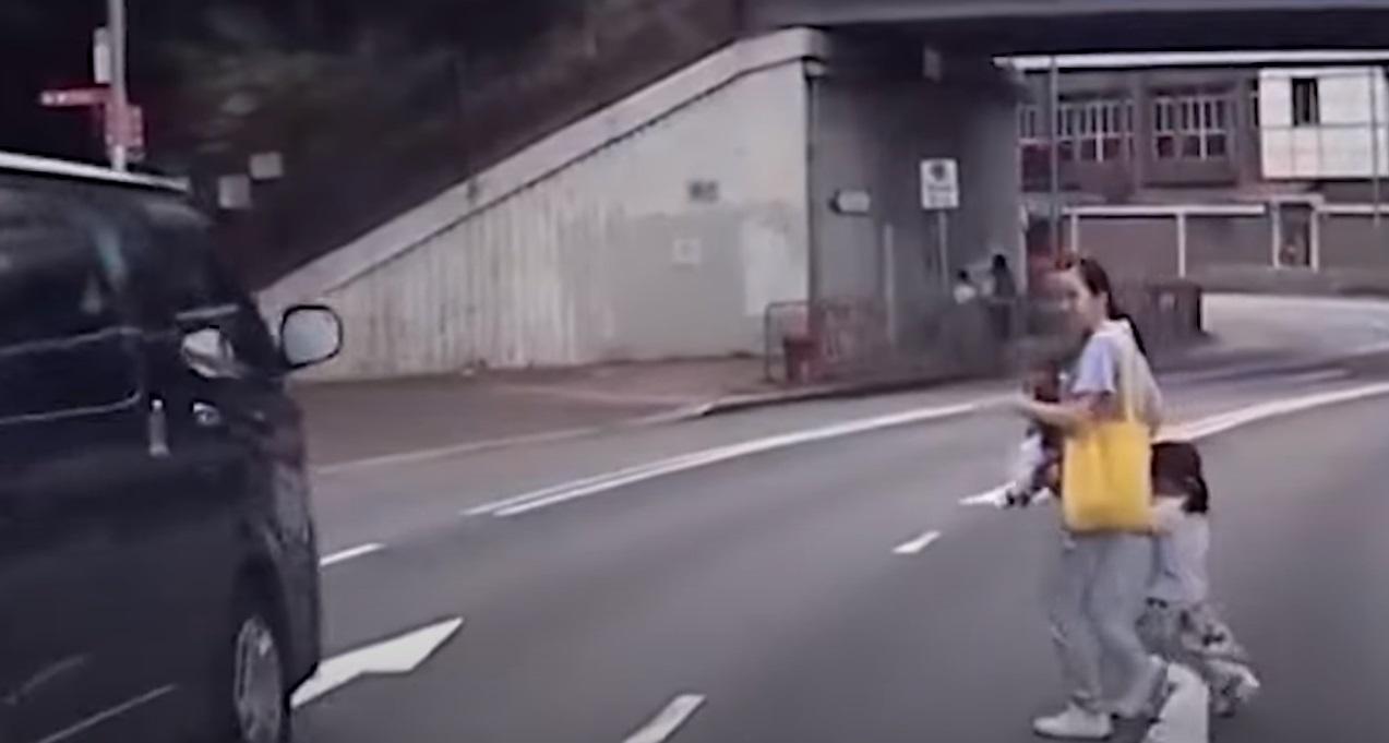 中年婦「一拖二」過馬路,行駛車輛需減速讓路。(網片截圖)