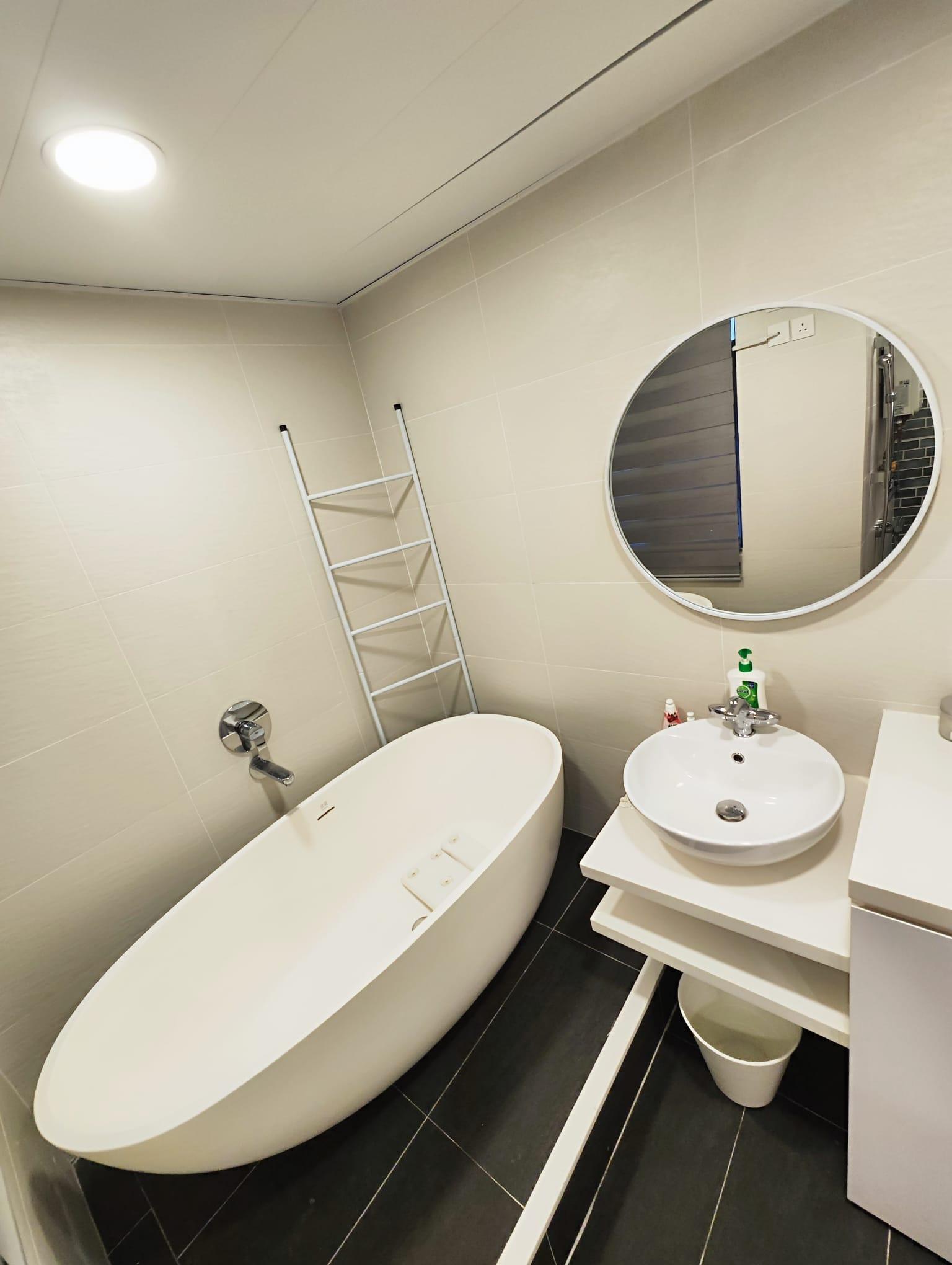 浴室選用橢圓形浴缸和圓形鏡子,設計精緻實用。