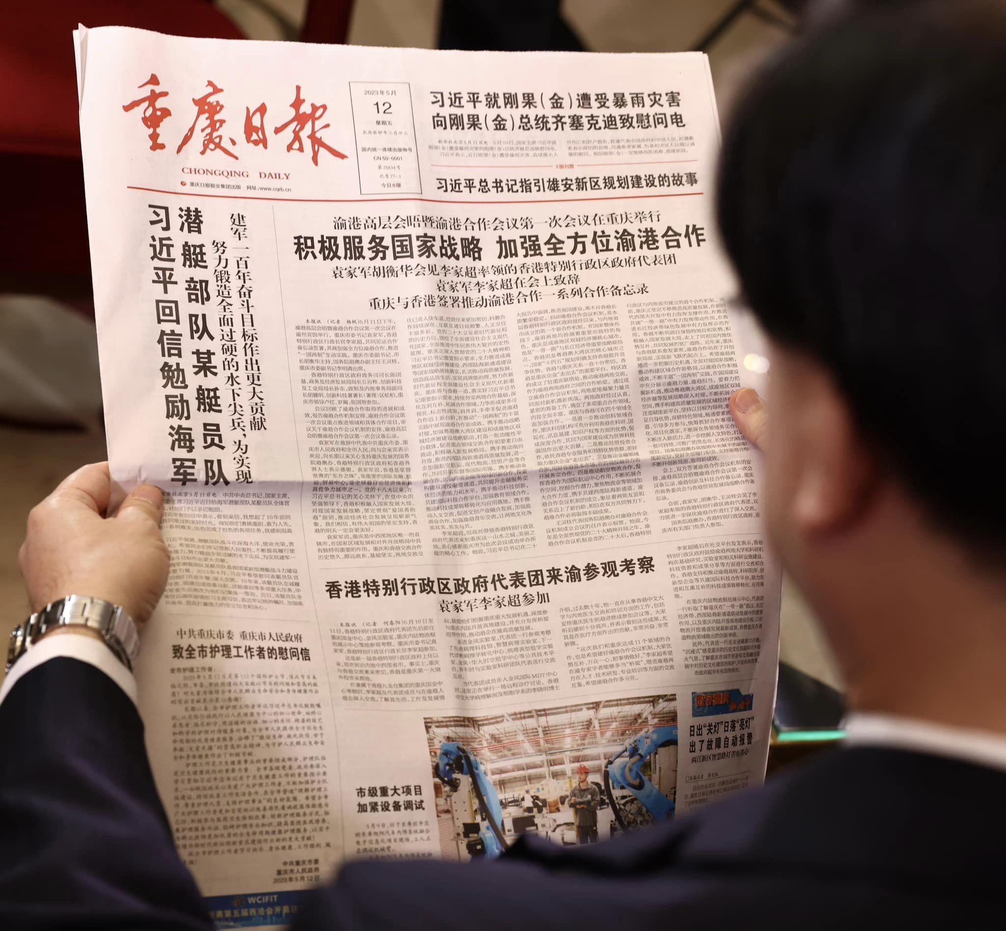 李家超訪重慶期間,爭取時間接受多間當地媒體訪問,並睇當地報紙。(李家超fb圖)