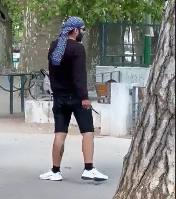 手持短刀的疑兇在公園內尋找目標。(影片截圖)