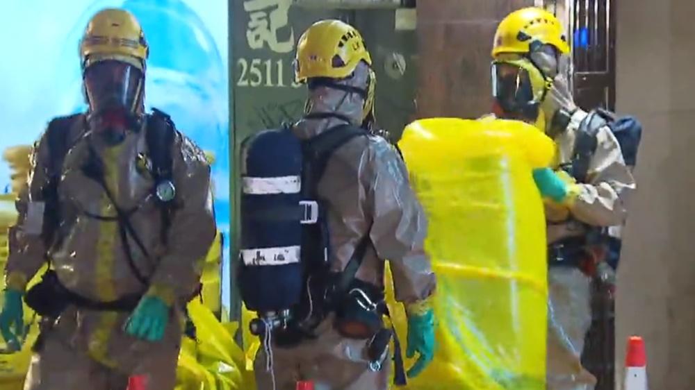 至今日凌晨2時許,消防員帶走多包物件由一輛化學廢料處理車運走。(電視截圖)