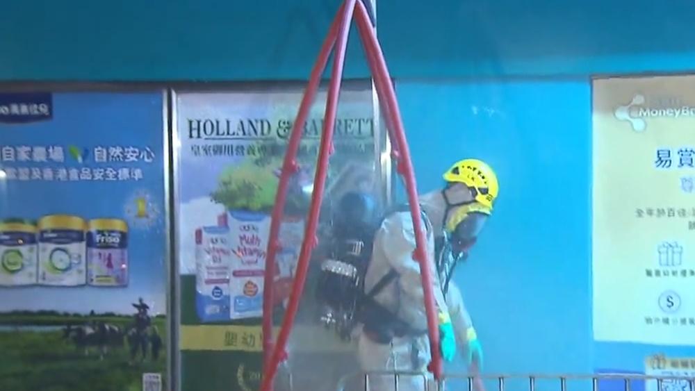 離開大廈的消防員,需要即場進行「洗消」程序,沖走身上的污染物。(電視截圖)