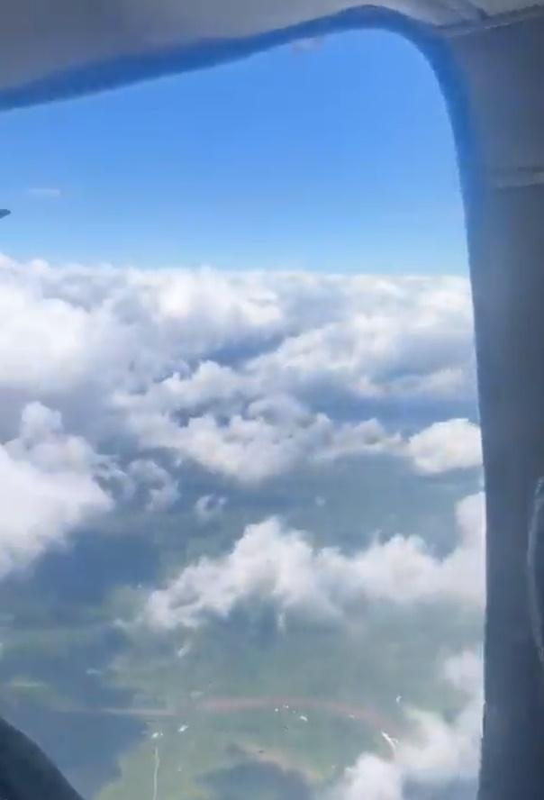 艙門外可見正於半空雲上,下方可見啡色河流。(Twitter)