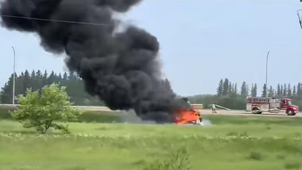 白色旅遊巴翻側和冒出大量濃煙。(網上圖片)