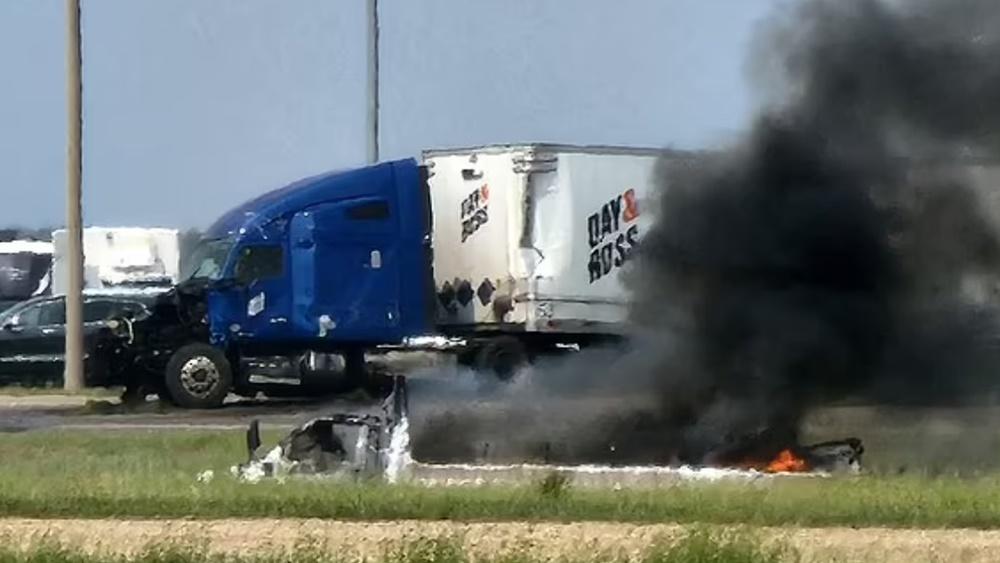 白色旅遊巴翻側和冒出大量濃煙。(網上圖片)