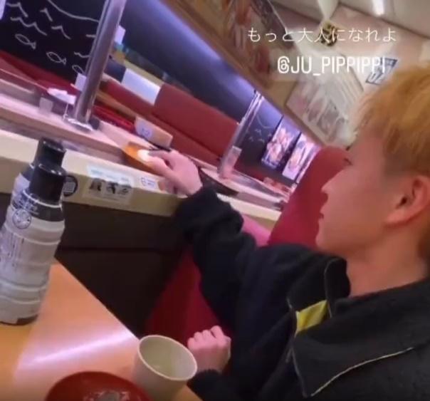 青年在看過周圍之後,再用舔過的手指,把口水沾到迴轉帶上的壽司。(影片截圖)