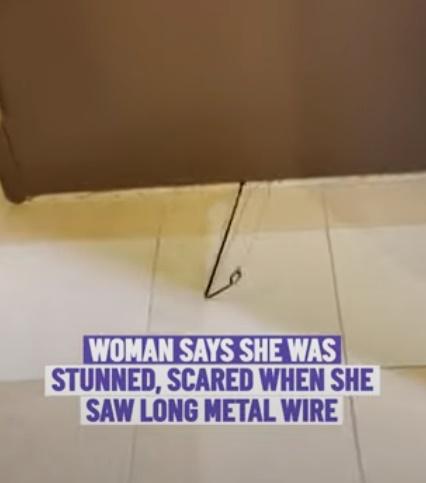 Debra發現有人在房門外,經房門底門縫將一枝長長的金屬工具攝入,試圖勾開房內門把。(YouTube)