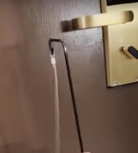 Debra發現有人在房門外,經房門底門縫將一枝長長的金屬工具攝入,試圖勾開房內門把。(YouTube)