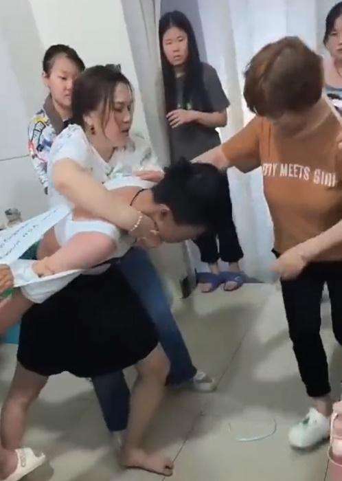 一名身穿黑色短裙的男子,正被多名女子壓制,甚至拉扯至衣衫不整。(Twittter)