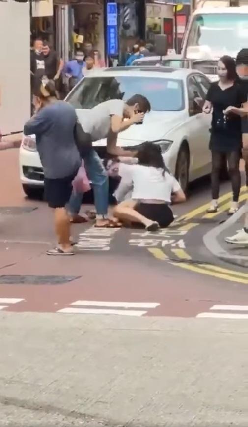 灰衣男用手推了黑裙女一下。(網片截圖)