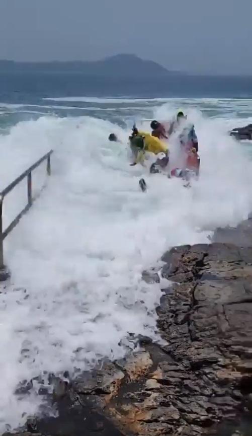 眾士站不住腳,遭巨浪沖至另一面。(網片截圖)