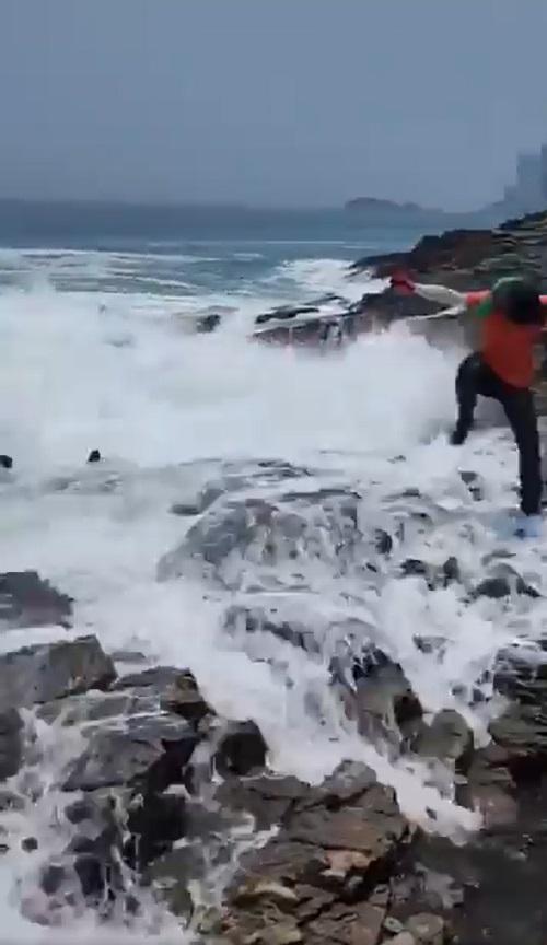 巨浪不斷打上岸,有人連忙跳起身回避。(網片截圖)