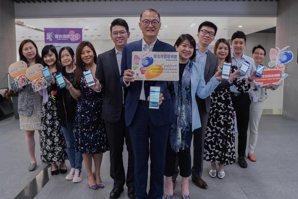 盧寵茂(中)、李夏茵(右五)和祁志鴻(左五)與一眾醫衞局職員,到場支持器官捐贈攤位。(醫務衞生局FB)