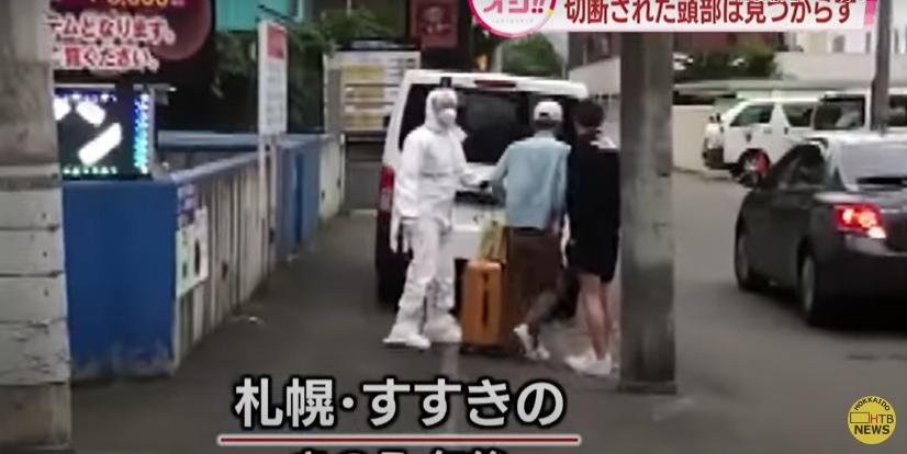 日本發生恐怖肢解案,警員在案發的札幌酒店外跟準備入住的人溝通。(互聯網)