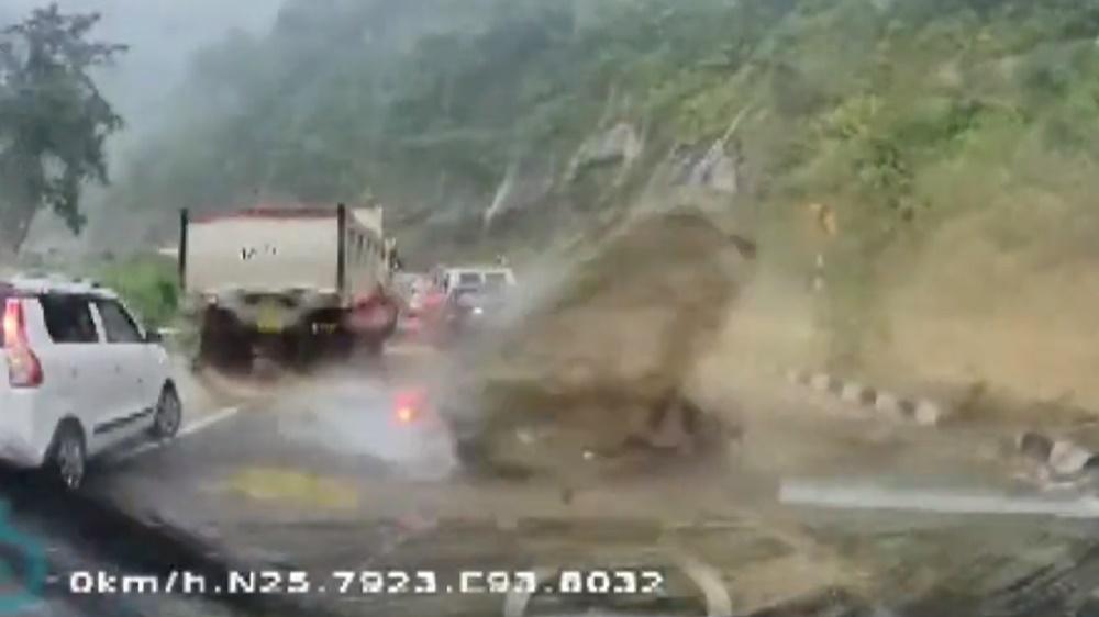 一顆巨石突然從右邊擊中一輛黑色汽車,黑色汽車瞬間被壓扁成為廢鐵。(Twitter)