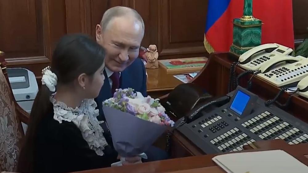 普京甚至將辦公桌位置讓給Raisat Akipova坐,期間不時展露和靄慈祥的笑容。(Twitter)