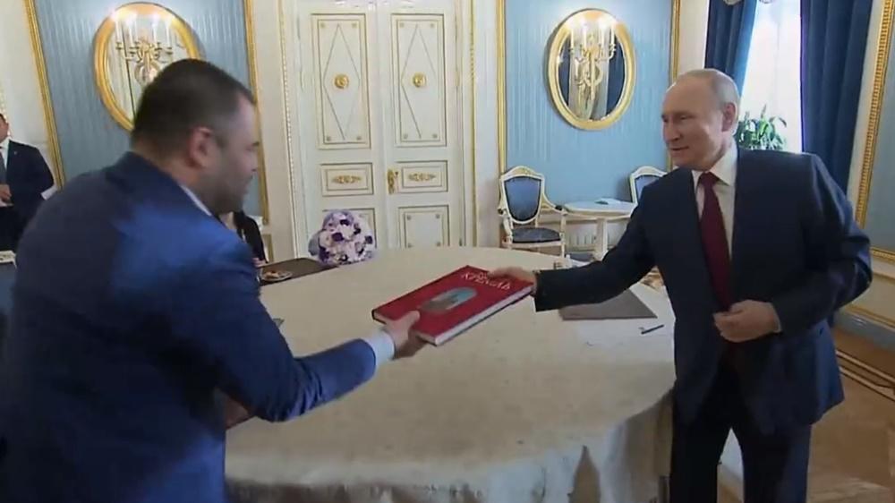 普京最後在一本紀念冊上簽名,並送給這家人。(Twitter)