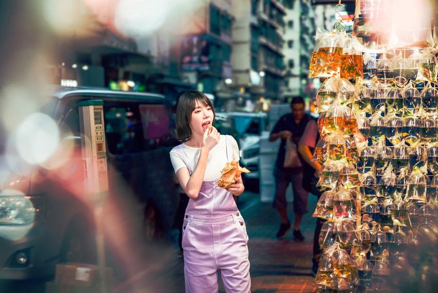 林明禎吃著雞蛋仔逛金魚街。