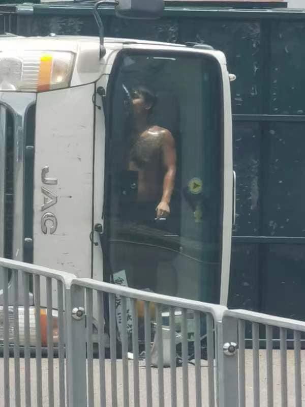 貨車司機被困駕駛室,唯有淡定食煙待救。(網上圖片)