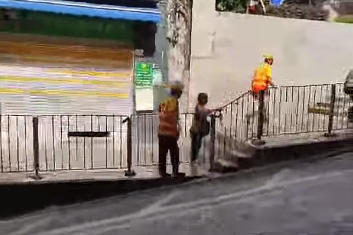 西營盤有婆婆被困爆水管「激流」,地盤工人見狀上前「公主抱」助脫困。(網民Ca Yue@FB群組「西環變幻時」影片截圖)