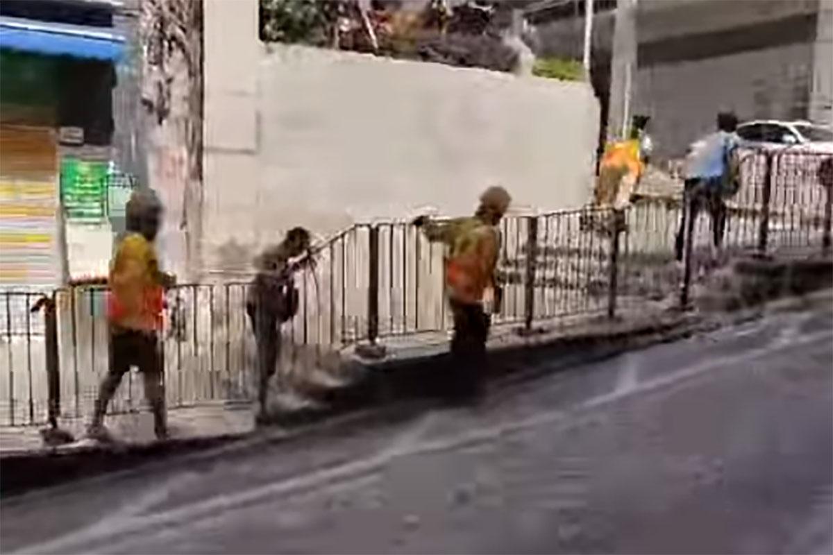 西營盤有婆婆被困爆水管「激流」,地盤工人見狀上前「公主抱」助脫困。(網民Ca Yue@FB群組「西環變幻時」影片截圖)