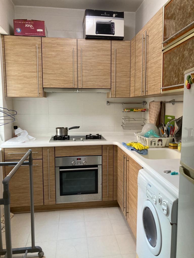 廚房設有L型流理台及一列組合櫃,下廚空間充裕。(代理提供)