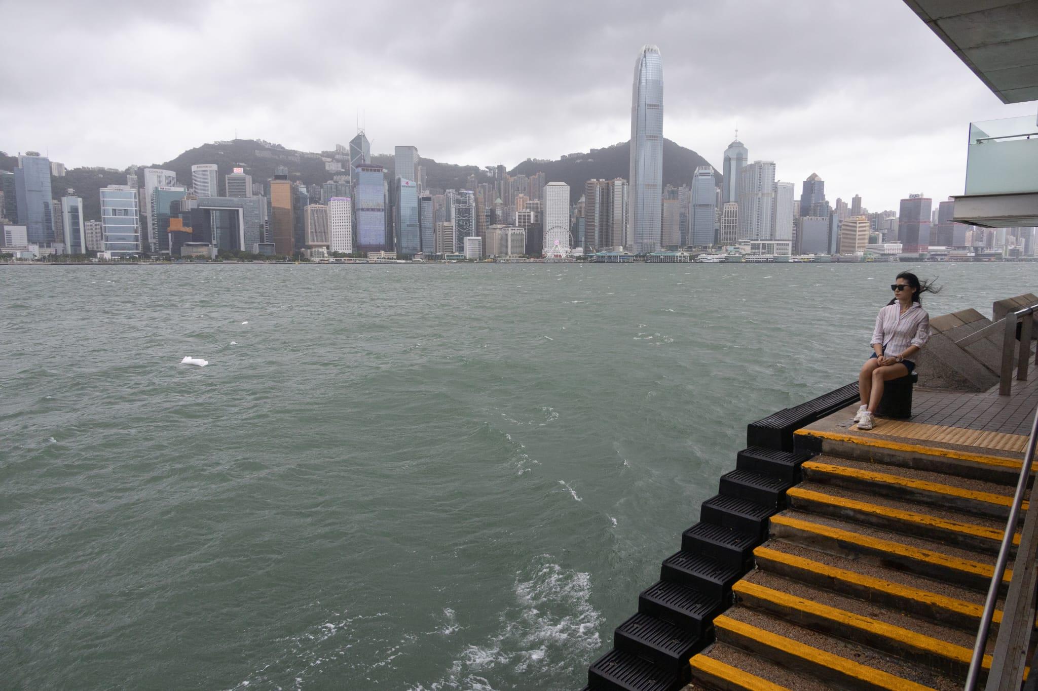 有女士在岸邊感受「泰利」的威力。(蘇文傑攝)
