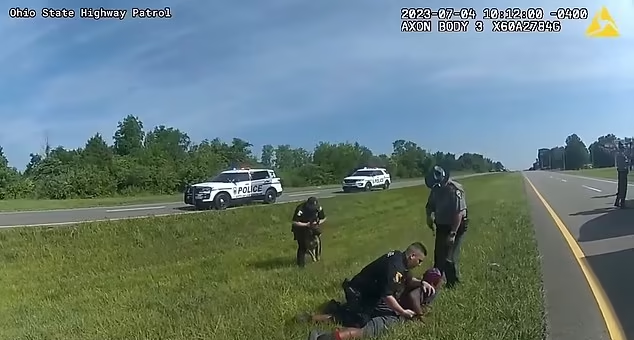 黑人司機舉雙手半跪投降,仍遭美警放咬狗。(互聯網)