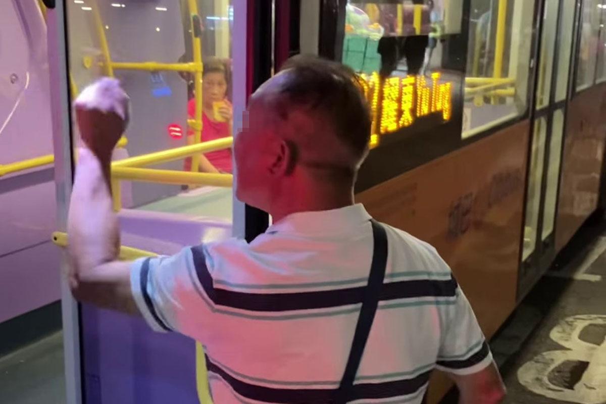 鰂魚涌惠安苑巴士站有巴士疑被私家車阻礙埋站,一名中年漢落車後多番折返及指罵車長「×你老×」。(網民Anson Lau影片截圖@FB群組「車cam L(香港群組)」)