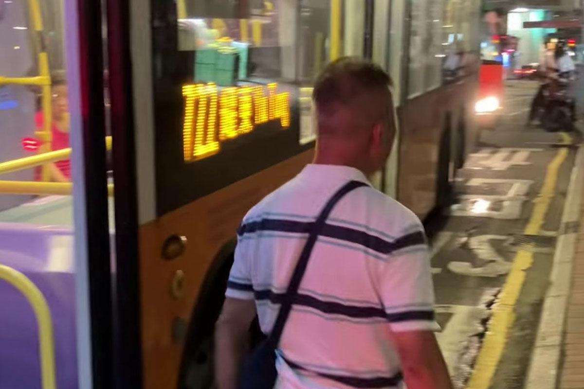 鰂魚涌惠安苑巴士站有巴士疑被私家車阻礙埋站,一名中年漢落車後多番折返及指罵車長「×你老×」。(網民Anson Lau影片截圖@FB群組「車cam L(香港群組)」)