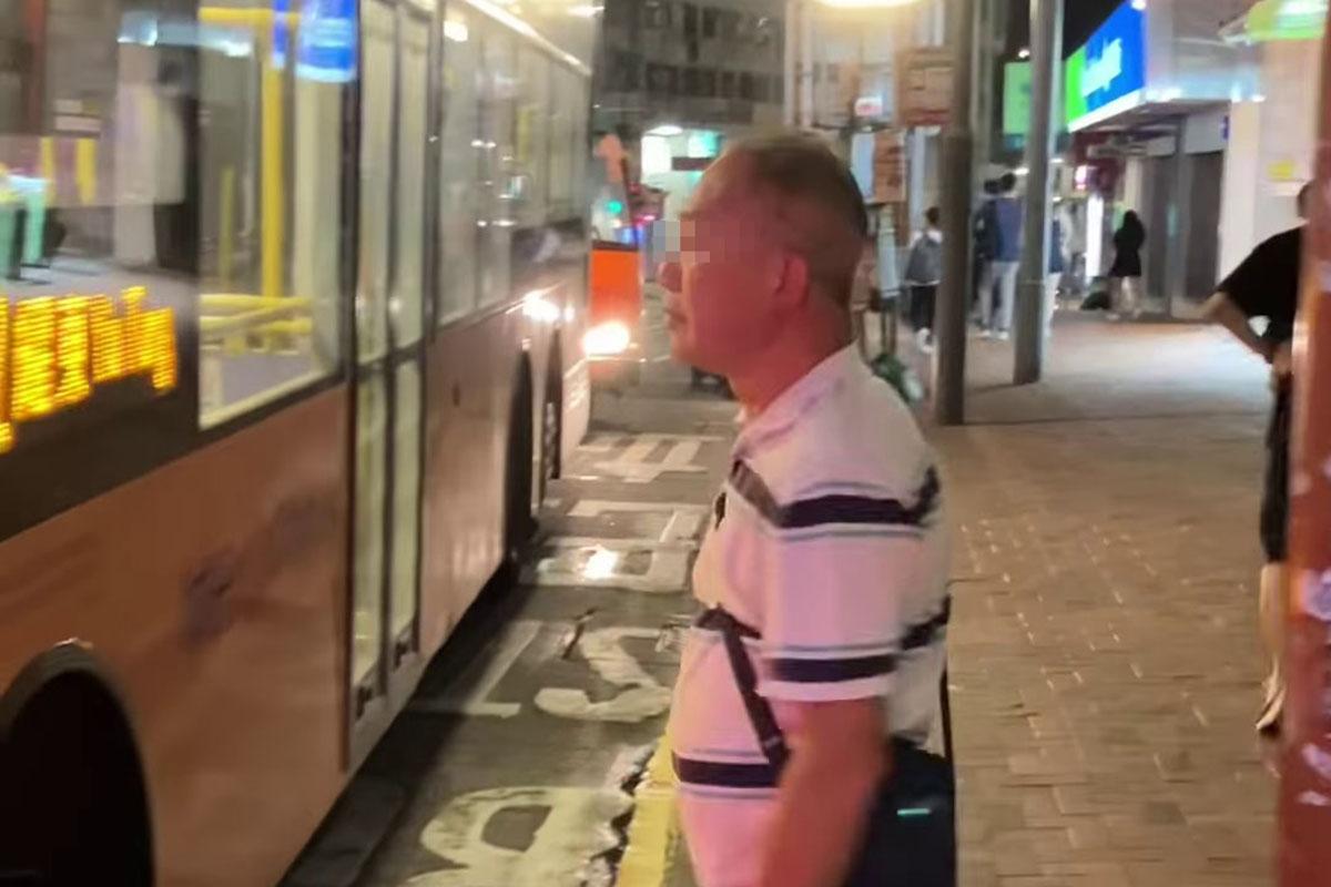 鰂魚涌惠安苑巴士站有巴士疑被私家車阻礙埋站,一名中年漢落車後多番折返及指罵車長「×你老×」。(網民Anson Lau影片截圖@FB群組「車cam L(香港群組)」)