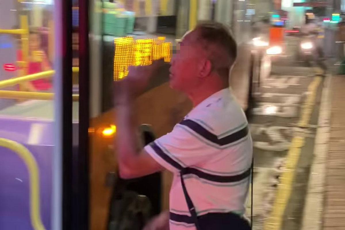 鰂魚涌惠安苑巴士站有巴士疑被私家車阻礙埋站,一名中年漢落車後多番折返及指罵車長「×你老×」。(網民Anson Lau影片截圖@FB群組「車cam L(香港群組)」)