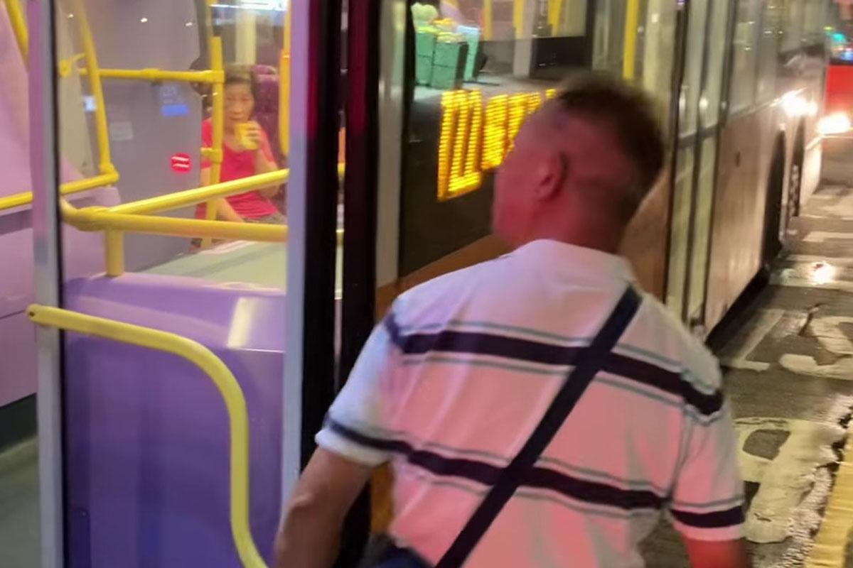 鰂魚涌惠安苑巴士站有巴士疑被私家車阻礙埋站,一名中年漢落車後多番折返及指罵車長「×你老×」。(網民Anson Lau影片截圖@FB群組「車cam L(香港群組)」)